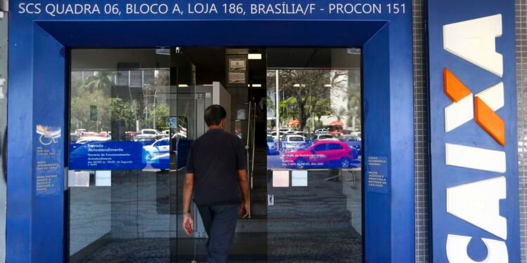 Foto de homem entrando na agência bancária da Caixa
