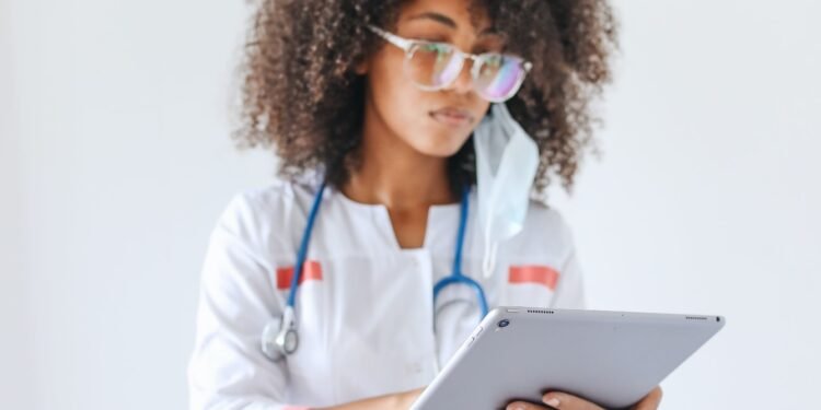 profissional de saúde com estetoscópio e tablet em mãos