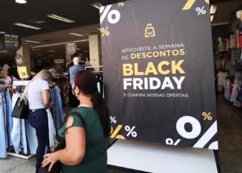 Foto consumidor fazendo compras com placa Black Friday