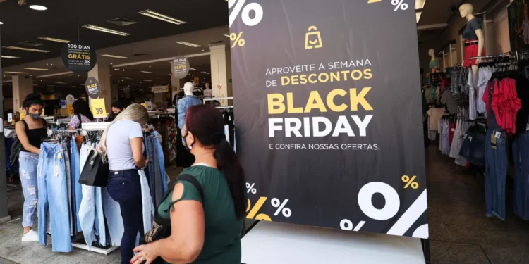 Foto consumidor fazendo compras com placa Black Friday