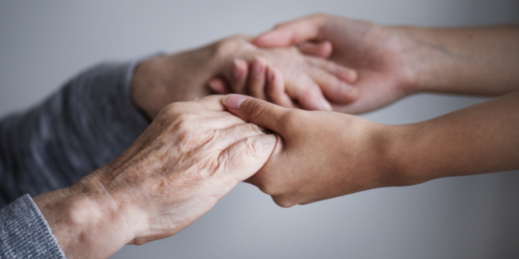 Foto mãos idosa e uma pessoa adulta