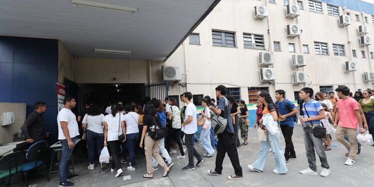 Foto estudantes entrando em escola para prestar Enem