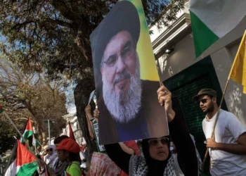 Foto de manifestante com foto de líder do Hezbollah em mãos