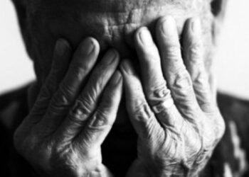 Foto idoso com as mãos no rosto