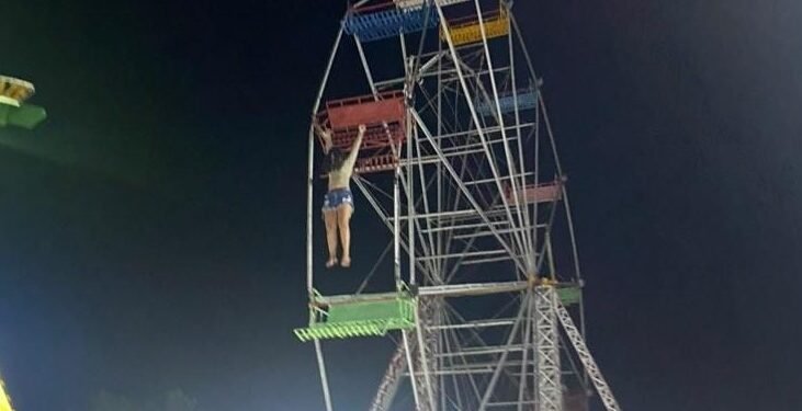 Foto adolescente presa pelos braços em roda gigante