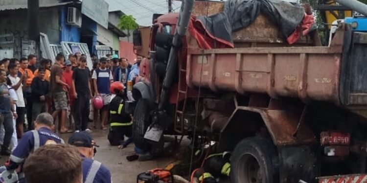 Motorista fica preso embaixo de pneu da caçamba dirigida por ele