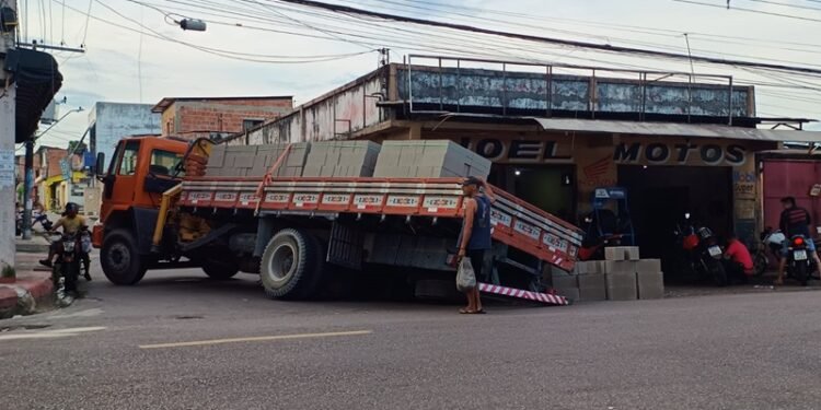 Asfalto cede e roda de caminhão é engolida por cratera