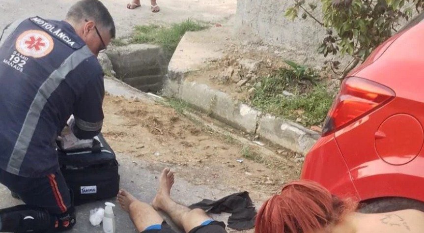 Agente do SAMU presta socorros ao motociclista envolvido no acidente (Foto: Reprodução/ Redes sociais)