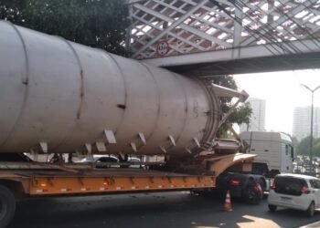 Motorista é multado após carreta fica presa em passarela