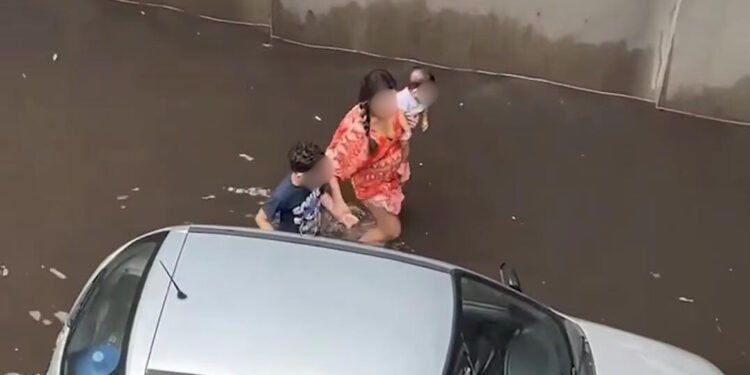 Vídeo: mulher com crianças luta para retirar carro preso durante alagamento em viaduto