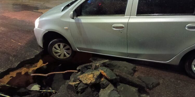 O carro caiu na cratera ampliada pelas chuvas (Foto: Reprodução/Redes Sociais)