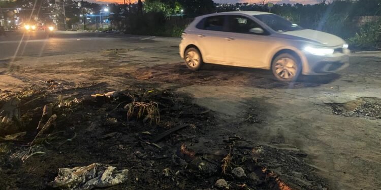 Moradores queimam pneus e fecham rua em protesto contra buracos no Distrito Industrial 2